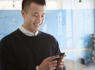 Happy man texting on his phone